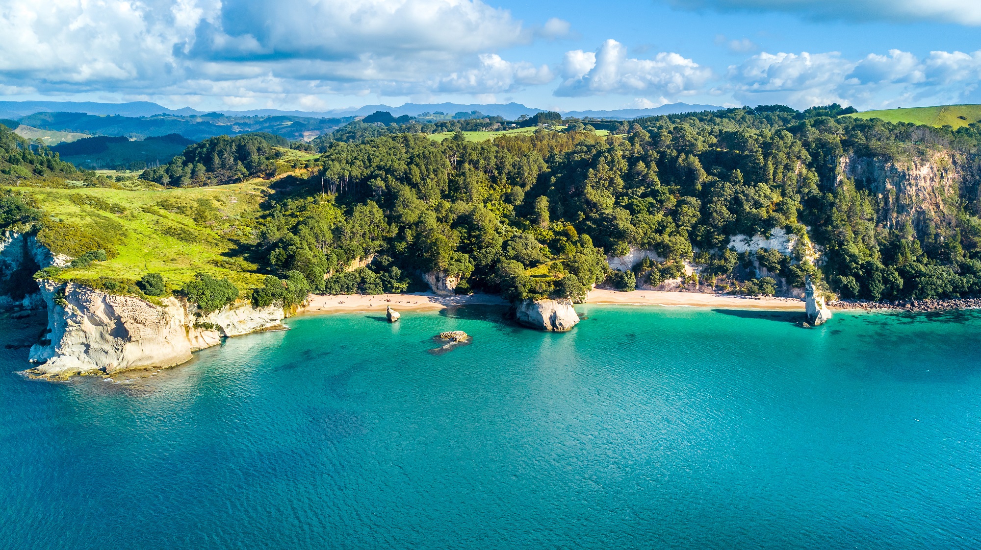 Vue aérienne sur les criques aux eaux turquoise et plaines du Coromandel en Nouvelle Zélande