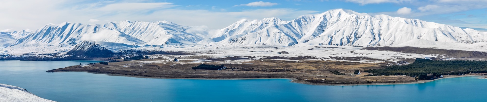 Vue panoramique sur le Lac Tekapo avec les montagnes enneigées en arrière plan