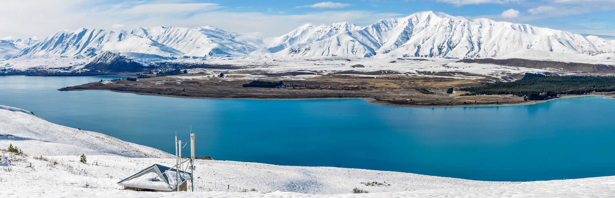 Vue panoramique sur le Lac Tekapo avec les montagnes enneigées en arrière plan